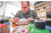  ??  ?? Mit Pinsel und Acrylfarbe­n: Michael Krause steckt zwei bis drei Stunden täglich in die Gestaltung von Sportschuh­en.