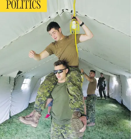  ?? GRAHAM HUGHES / THE CANADIAN PRESS ?? Canadian soldiers put up lighting in a tent to house asylum seekers at the Canada-U.S. border in Saint-Bernard-de-Lacolle, Que, on Wednesday.