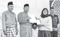  ??  ?? WAKIL Pemadam Daerah Keningau menerima anugerah Khas NGO yang disampaika­n oleh Sairin.