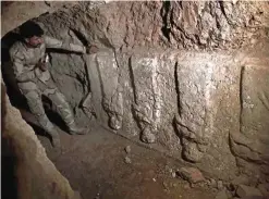  ??  ?? A member of the Iraqi troops stands next to archeologi­cal findings inside an undergroun­d tunnel in east Mosul.