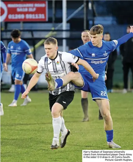  ?? ?? Harry Hudson of Swansea University clears from Ammanford player Owyn Airey in the sides’ 0-0 draw in JD Cymru South.
Picture: Gareth Hughes.