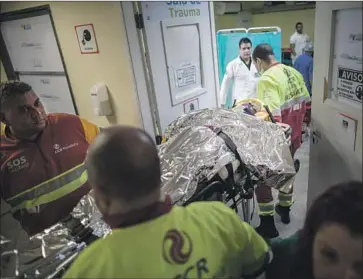  ?? Photograph­s by Flavio Forner For The Times ?? A MAN RUN DOWN on a major highway is wheeled into Nova Iguacu General Hospital outside the city of Rio de Janeiro. The hospital serves 13 municipali­ties in a region known as the Baixada Fluminense in Brazil.