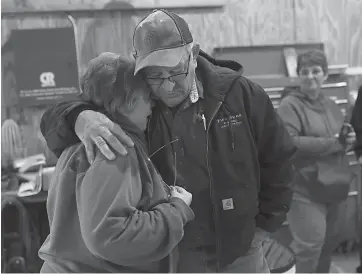  ?? Tribune News Service ?? Sue Hanson, partner of Steve Hemp, is hugged by her cousin Ed Hanson on Nov. 4 in Ashkum, Ill., during a lunch for farmers and friends who helped with harvesting corn. Hemp died in September.