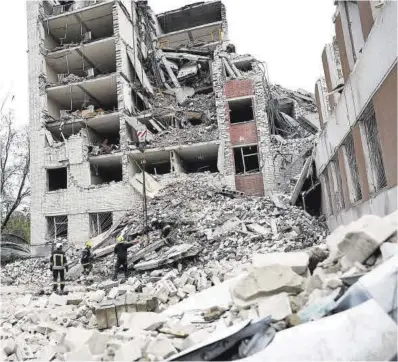  ?? Valentyn Ogirenko / Reuters ?? Los bomberos inspeccion­an un edificio destruido en un ataque con misiles rusos en la ciudad de Chernihiv.