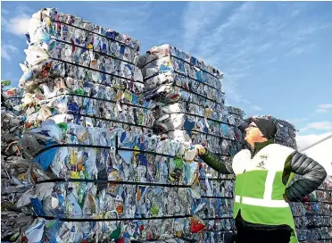  ?? JOHN HAWKINS/ STUFF ?? Hamish Mcmurdo General Manager of Southland disAbility Enterprise with bails of compressed plastic bottles and janitorial containers.