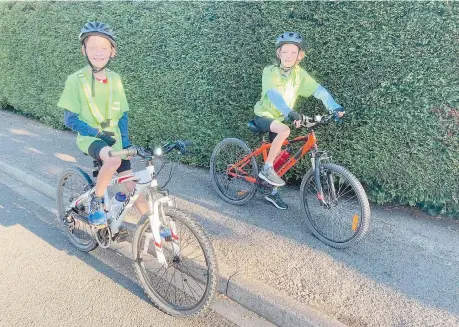  ?? ?? Samuel and Theodore Tan all ready to go on their mammoth bike ride with father Stephen. Photo by Melissa Carr.