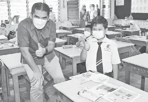  ?? — Gambar Bernama ?? TURUN PADANG: Radzi bersama dengan murid tahun satu, Aidil Shahfitri, ketika mengadakan lawatan kerja di Sekolah Kebangsaan Tengku Zainun, semalam.