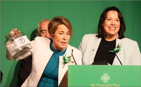  ?? NANCY LANE — BOSTON HERALD ?? Governor Maura Healey and Lieutenant Governor Kim Driscoll hold their version of a swear jar for basketball references and mentions of the T during the St. Patrick’s Day Breakfast on Sunday.