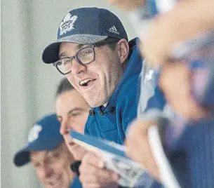  ?? RICK MADONIK/TORONTO STAR PHOTOS ?? Leafs GM Kyle Dubas looks on at the opening day of camp, where defenceman Mac Hollowell, left, wasn’t the only Soo connection among the 46 skaters at the MasterCard Centre.