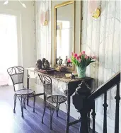  ?? HENRIETTA SOUTHAM ?? In her foyer, designer Henrietta Southam playfully pairs an ornate 18th-century Trumeau mirror of her mother’s with a birch bark and branch console and Cole & Son Woods and Pears wallpaper. Murano leaf sconces frame the mirror and a Jason Miller...