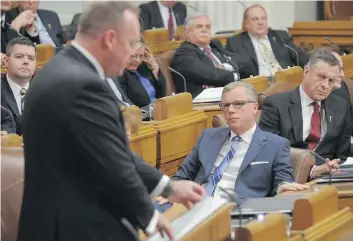  ?? MARK TAYLOR/THE CANADIAN PRESS ?? Premier Brad Wall listens to Finance Minister Kevin Doherty’s 2017 budget speech on March 22. The controvers­ial austerity plan sparked anger and criticism all around the province,