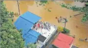  ?? REUTERS ?? ▪ People wait for aid on the roof of a house in a flooded area of Kerala on Friday.