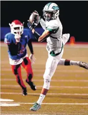  ?? [PHOTO BY STEVE SISNEY, THE
OKLAHOMAN] ?? Jones’ Callen Houston catches a Brandon George pass during the Class 3A semifinal game against the John Marshall Bears on Friday in Moore.