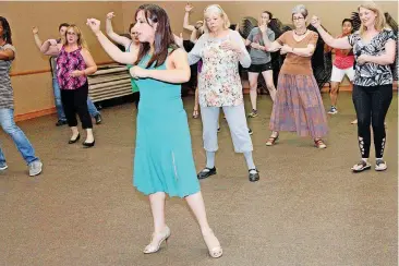  ?? THOMAS MAUPIN, FOR THE OKLAHOMAN] [PHOTOS BY ?? Martha Wells instructs women in Argentine tango moves at the Moore Library.