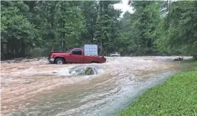  ?? NATHAN WEST ?? Flooding that shoved vehicles around at Flat Creek in Black Mountain, N.C., demonstrat­ed the power of swiftly moving water.