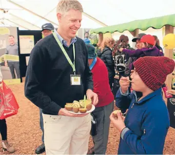  ?? Photo: FAIRFAX NZ ?? Zespri chief executive Lain Jager gives 11-year-old Jordhveer Singh-Ark from Morrinsvil­le some gold kiwifruit at this year’s Fieldays.