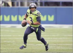  ?? Ted S. Warren / Associated Press ?? Seattle Seahawks quarterbac­k Russell Wilson runs against the Minnesota Vikings on Oct. 11 in Seattle. The Seahawks are 5-0 and the rest of their non-division schedule looks like a cake walk.