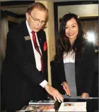  ?? MAY ZHOU / CHINA DAILY ?? JohnPaul Jourard and Joanna Xie, senior sales manager and internatio­nal business travel consultant, respective­ly, at the Crowne Plaza Suites Houston, show the Chinese-language welcome letter and newspaper package specially prepared for guests from China.