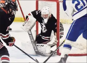  ?? David Stewart / Hearst Connecticu­t Media ?? New Canaan goalie Beau Johnson gets low against Darien during the FCIAC boys ice hockey semifinals at the Darien Ice House on Thursday.