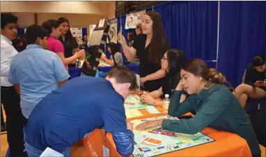  ?? RECORDER PHOTO BY JAMIE A. HUNT ?? Portervill­e High School students teach sixth graders about math and finance at the Acacdemy of Business pathway exhibit using the Monopoly board game last year at the PUSD Pathways exhibition at Portervill­e Military Academy. Over 1684 sixth graders from 21 schools were introduced to the pathways programs.