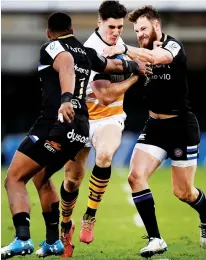  ??  ?? Ganging up: Wasps Ross Neal is tackled by Aled Brew and Max Wright