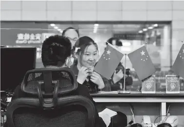  ??  ?? A medical worker from Xinhua Hospital completes the immigratio­n formalitie­s before boarding a London-bound flight to ferry back 180 Chinese students from UK. — Ti Gong