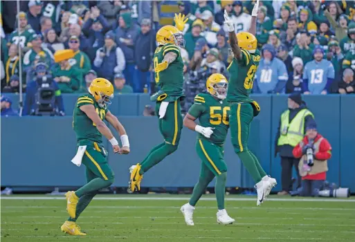  ?? MIKE ROEMER/AP ?? Quarterbac­k Jordan Love (from left) and receivers Christian Watson and Romeo Doubs are jubilant during the Packers’ victory Sunday.