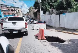  ?? FOTO: EMILIO FLORES ?? El agujero solo se encuentra señalizado para alertar a los conductore­s pero no se ha brindado respuesta para reparar la vía.