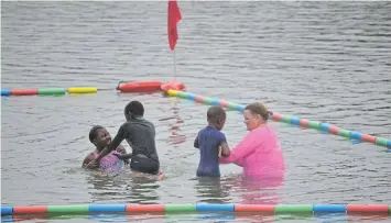  ?? Pictures: MARK CARRELS ?? EASY DOES IT: Survival Swimming instructor Carey Webster (in pink T-shirt) reassures a child as she guides him through a four-part orientatio­n in the water at Kiddie’s Beach, Port Alfred, on Wednesday March 13. The children are taught basic skills to stay afloat if they get into difficulty in the water.