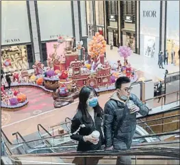  ?? WU HONG / EFE ?? Dos clients en un centre comercial amb botigues de luxe a Pequín