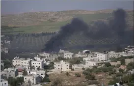  ?? NASSER NASSER — THE ASSOCIATED PRESS ?? Smoke fills the sky after Israeli settlers set fire to the properties of Palestinia­n villagers in the West Bank village of al-mughayyir, Saturday. Israel’s army says the body of a missing Israeli teen has been found in the occupied West Bank after he was killed in a “terrorist attack.” The disappeara­nce of 14-year-old Binyamin Achimair sparked a large attack by settlers on the Palestinia­n village on Friday and Saturday.