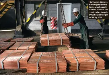  ?? ?? High hopes: Workers move copper sheets from a warehouse in
Mufulira, Zambia. The country aims to up its annual copper output to 3Mt by 2031