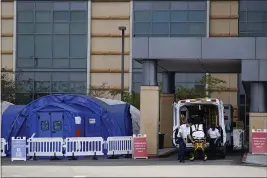  ?? ASHLEY LANDIS — AP PHOTO, FILE ?? Medical workers remove a stretcher from an ambulance near medical tents outside the emergency room at UCI Medical Center in Irvine. Doctors said Friday increasing­ly desperate California hospitals are being “crushed” by soaring coronaviru­s infections.