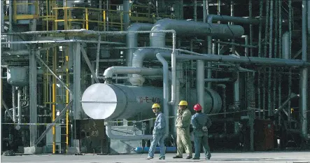  ?? GUANG NIU/GETTY IMAGES FILES ?? Staff work at Dushanzi Petrol Chemical Factory, owned by China National Petroleum Corp., the parent of PetroChina Co., in Dushanzi in China’s Xinjiang province. Investors are hungry for a spinoff of PetroChina and its parent amid low prices and...