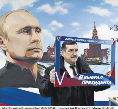  ?? AFP ?? Un hombre posa junto a un mural con Vladímir Putin en una escuela de Donetsk convertida en centro de votación, ayer. La ciudad es capital de una de las provincias ucranianas anexionada­s parcialmen­te por Rusia.