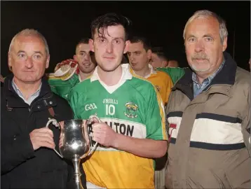  ??  ?? Stephen Watchorn receives the cup from Murt Joyce (sponsor) as Seamus Whelan (Enniscorth­y District Secretary) looks on.