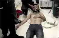  ??  ?? Video provided by an anti-Bashar Assad group that is consistent with independen­t Associated Press reporting shows a man lying on the floor of a hospital room being given oxygen after a reported poison-gas attack Friday in Kfar Zeita, Syria.