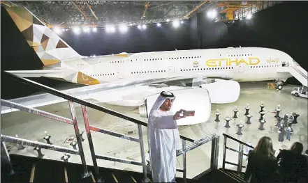  ?? (AP) ?? In this file photo, an Emirati man takes a selfie in front of a new Etihad Airways A380 in Abu Dhabi, United Arab Emirates. The parent company of Etihad Airways has named a British military official who once oversaw Abu Dhabi Internatio­nal Airport as...