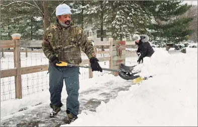  ??  ?? JJ McKinney shovels snow in front of his residence on France Street.