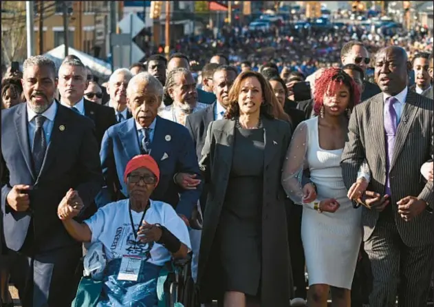  ?? AFP/GETTY ?? Vice President Kamala Harris, center, flanked by the Rev. Al Sharpton, left, and lawyer Benjamin Crump, far right, leads march across Edmund Pettus Bridge in Selma, Ala., on Sunday, marking the 59th anniversar­y of Bloody Sunday on March 3, 1965, when civil rights protesters were attacked by police with batons and tear gas.