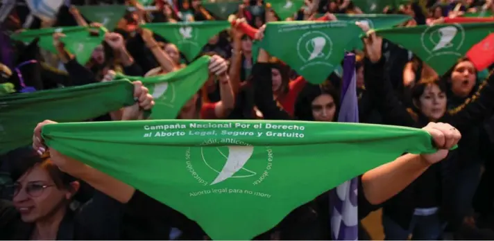  ?? ?? ► Un grupo de personas sostiene pañuelos verdes durante una manifestac­ión a favor del acceso al aborto seguro y legal, en Buenos Aires, el 28 de septiembre de 2023.