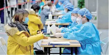  ?? — AFP photo ?? Medical workers register people to be inoculated with a Covid-19 vaccine at the Chaoyang Museum of Urban Planning in Beijing.