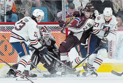  ?? DARRYL DYCK THE CANADIAN PRESS ?? Peterborou­gh Petes defenceman Sam Mayer defends against Kamloops Blazers’ Jakub Demek and Dylan Sydor in front of Peterborou­gh goalie Liam Sztuska during Memorial Cup hockey action in Kamloops, B.C., on Sunday night.