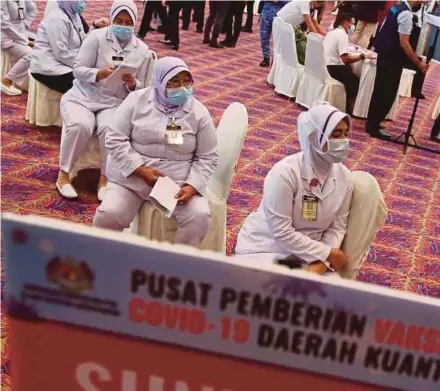  ?? PIC BY FARIZUL HAFIZ AWANG ?? Frontliner­s waiting to receive the Covid-19 vaccine at Dewan Jubli Perak Sultan Haji Ahmad Shah in Kuantan on Friday.