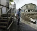  ?? CARLOS GIUSTI — THE ASSOCIATED PRESS ?? Juana Matos resident Hector Rosa walks through a flooded area after the passing of Hurricane Maria, in Puerto Rico, Wednesday. Since the devastatin­g impact of said hurricane, the supply line of goods in general was interrupte­d in the US territory,...