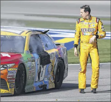  ?? STEVE MARCUS / LAS VEGAS SUN ?? Kyle Busch walks away from his smoking car after the NASCAR race at Las Vegas last Sunday before physically confrontin­g Joey Logano.