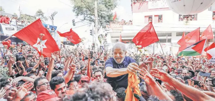  ??  ?? ►
Lula junto a simpatizan­tes en São Bernardo do Campo, horas antes de entregarse a la Policía Federal, el 7 de abril.