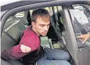  ?? [AP PHOTO] ?? In this Monday photo released by the Metro Nashville Police Department, Travis Reinking sits in a police car after being arrested in Nashville, Tenn. Police said Reinking opened fire at a Waffle House early Sunday, killing at least four people.