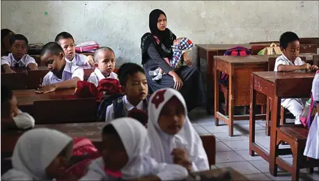  ?? SOFYANSYAH/RADAR BOGOR/JPG ?? BAYI PUN TERPAKSA SEKOLAH: Seorang ibu sambil menggendon­g si kecil menunggu anaknya di ruang kelas I SDN 08 Ciomas, Kabupaten Bogor, kemarin (17/7).
