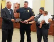  ?? EVAN BRANDT — DIGITAL FIRST MEDIA ?? Phoenixvil­le Mayor Michael Speck, left, administer­s the oath of office to Bryan MacIntyre, who was promoted to the rank of sergeant during the Aug. 8meeting of borough council, and gets a little help from his wife, State Trooper Kelly MacIntyre, and...